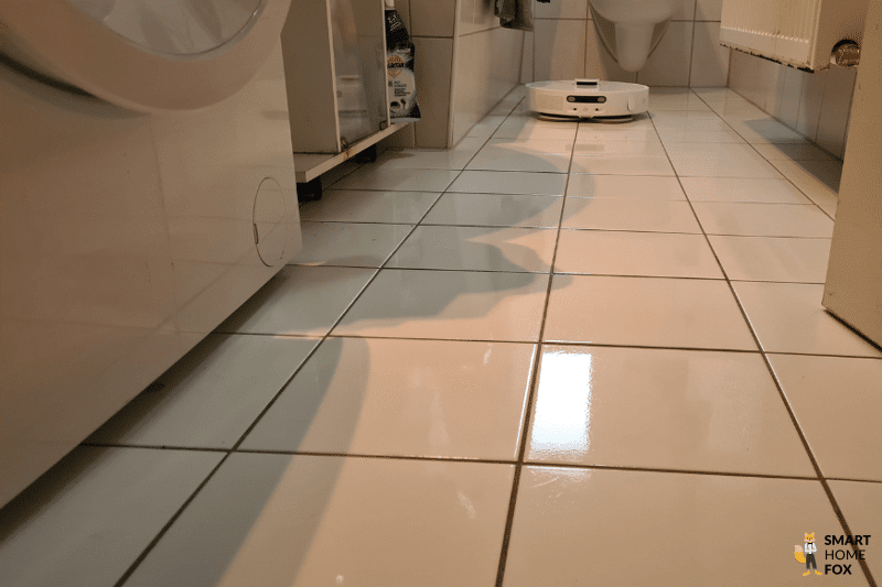 Ein Dreame Saug-Wischroboter wischt einen Fliesenboden im Badezimmer.
